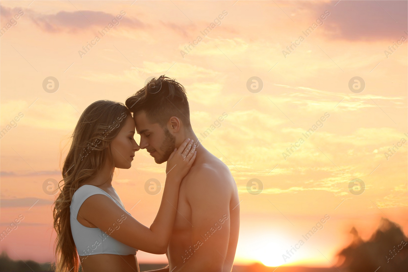 Photo of Happy young couple in beachwear outdoors at sunset