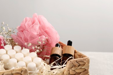 Photo of Spa gift set of different luxury products in wicker basket on table, closeup. Space for text