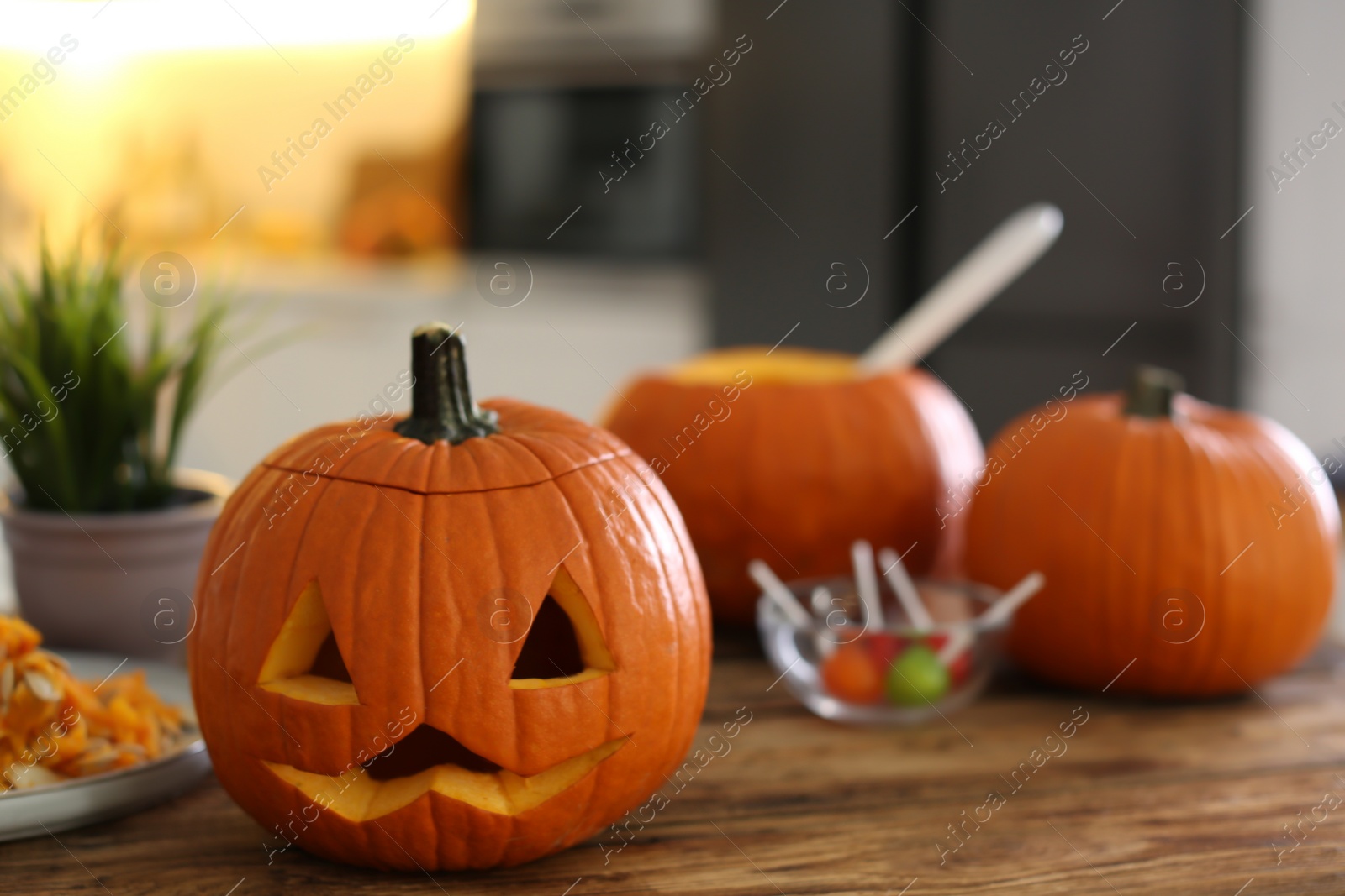 Photo of Pumpkin jack o'lantern on wooden table indoors, space for text. Halloween celebration