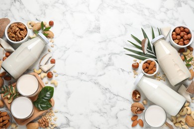 Photo of Vegan milk and different nuts on white marble table, flat lay. Space for text