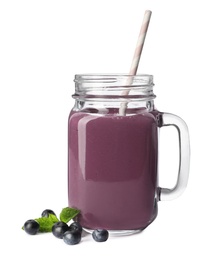 Mason jar of acai drink with berries on white background