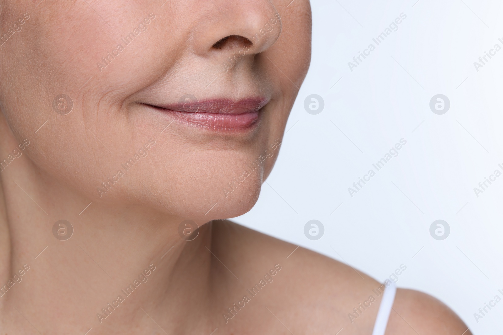 Photo of Senior woman with aging skin on white background, closeup. Rejuvenation treatment