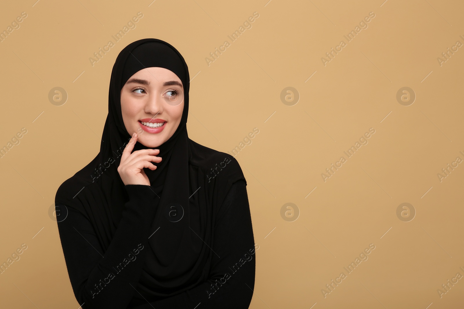 Photo of Portrait of Muslim woman in hijab on beige background, space for text