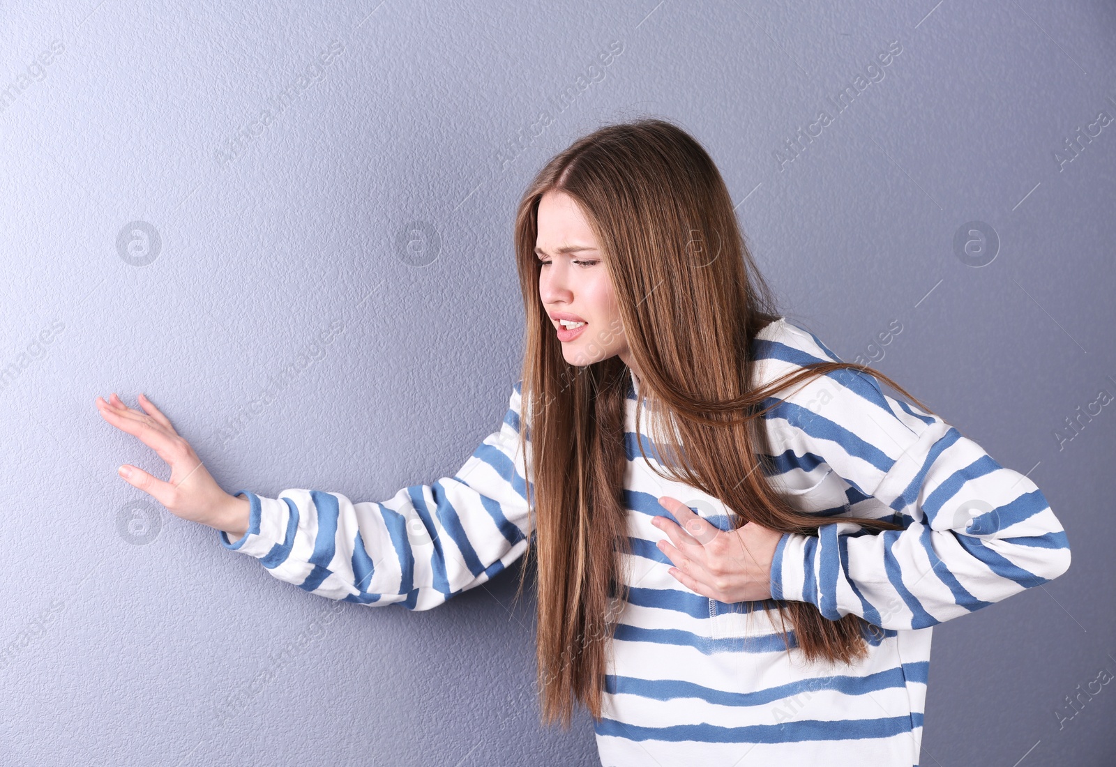 Photo of Young woman having heart attack on color background