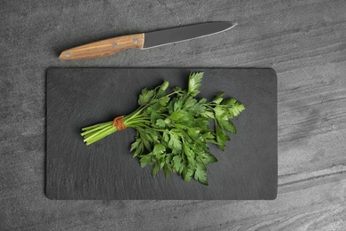 Photo of Flat lay composition with fresh green parsley and knife on grey background