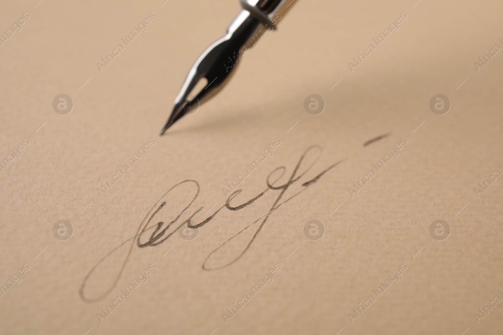 Photo of Signature and fountain pen on sheet of paper, closeup