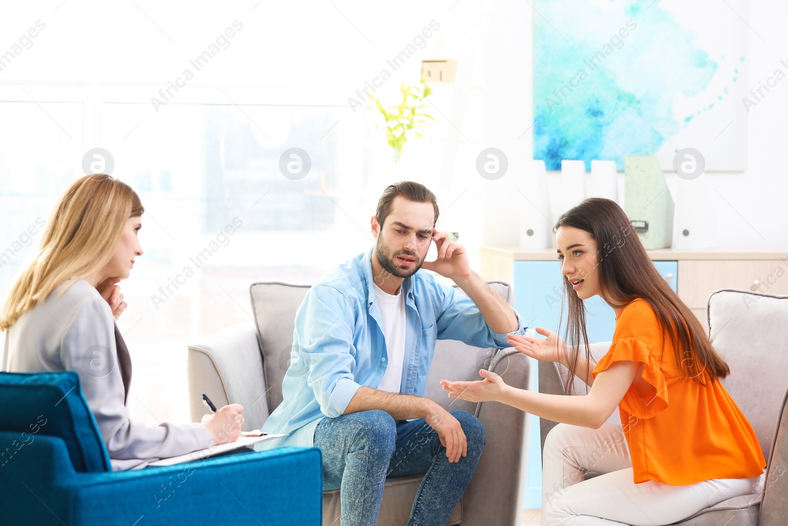 Photo of Family psychologist working with young couple in office