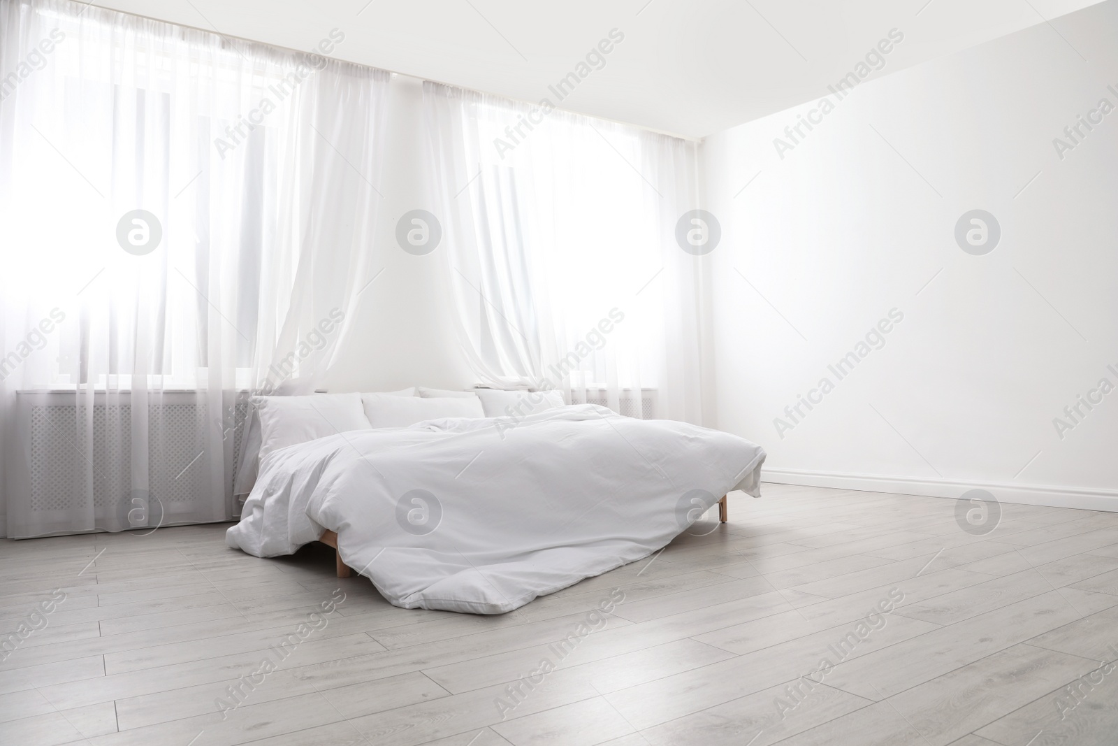 Photo of Comfortable bed in light room. Interior design