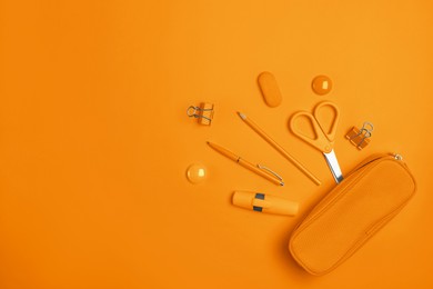 Image of Flat lay composition with pencil box and stationery on orange background. Space for text