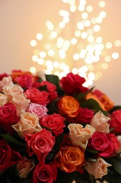 Photo of Beautiful bouquet of colorful roses on beige background, closeup