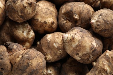 Photo of Many fresh Jerusalem artichokes as background, closeup