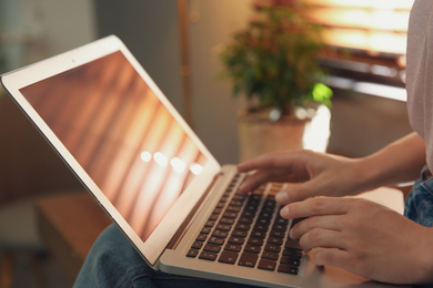 Photo of Woman working with modern laptop indoors, closeup