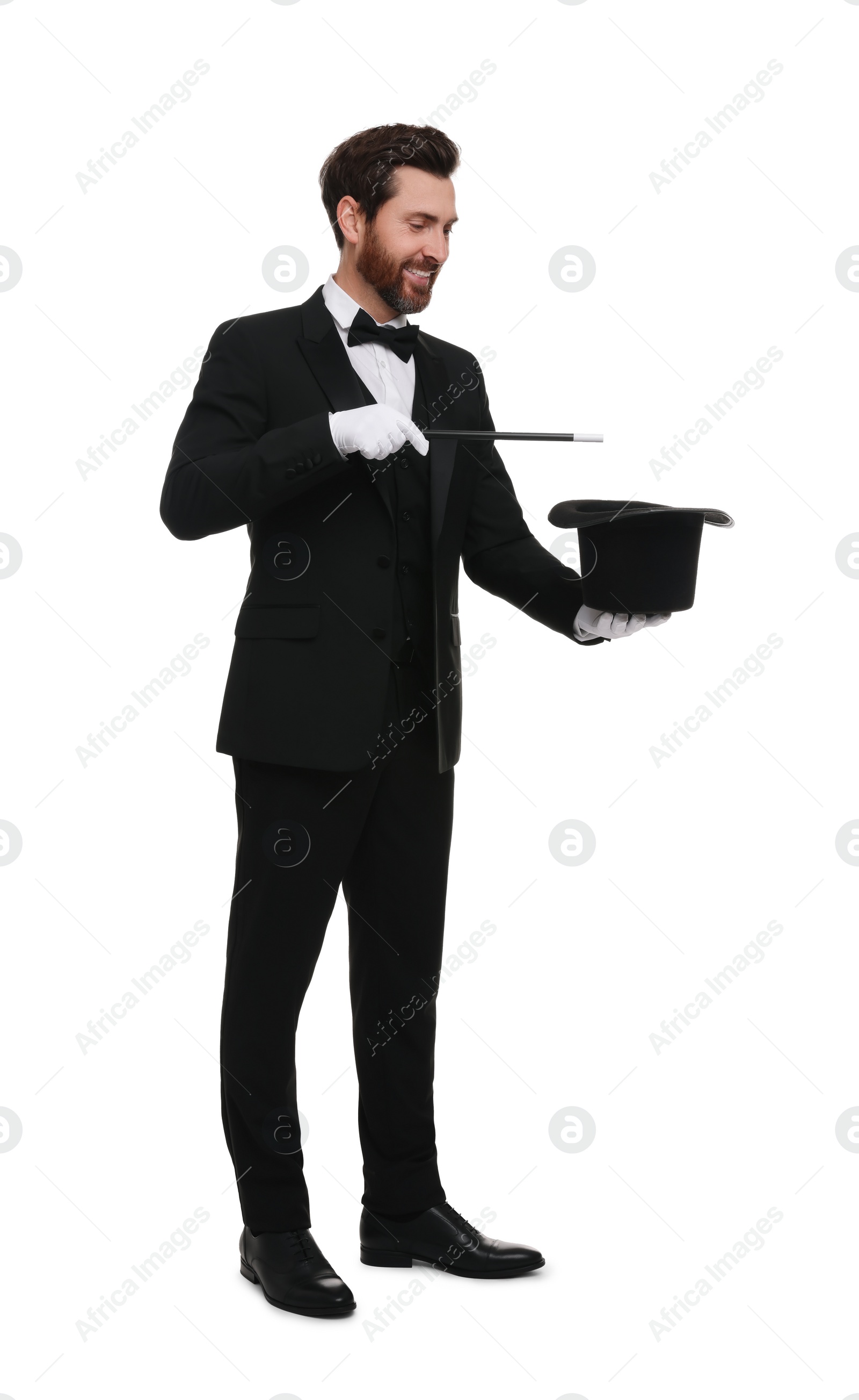 Photo of Happy magician showing magic trick with top hat on white background