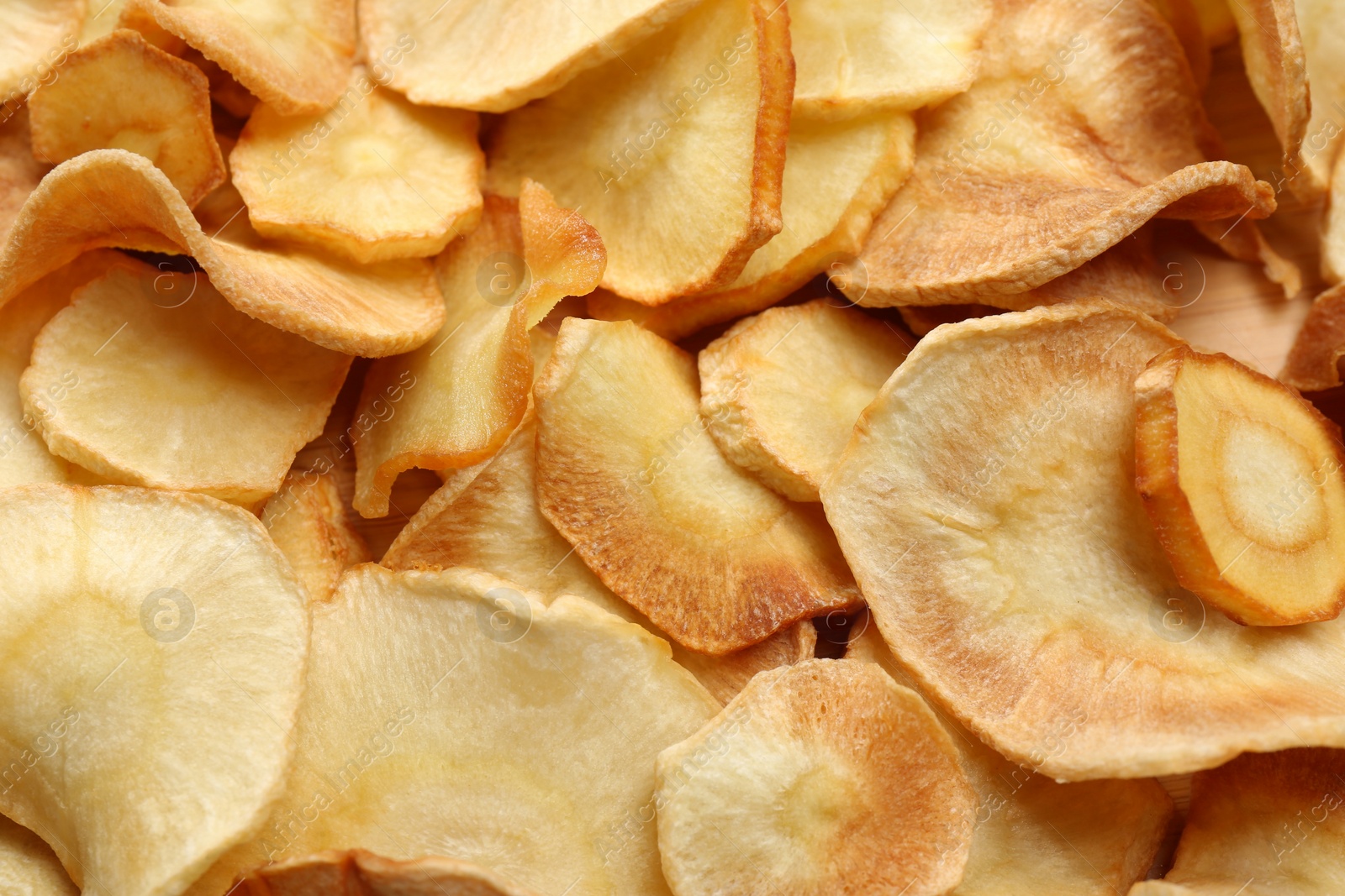 Photo of Tasty homemade parsnip chips as background, top view