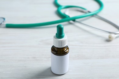 Photo of Nasal drops with blank label on white wooden table. Space for design