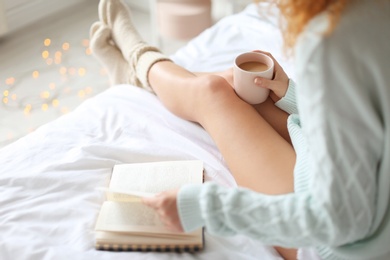 Photo of Young woman with sexy legs resting on bed at home