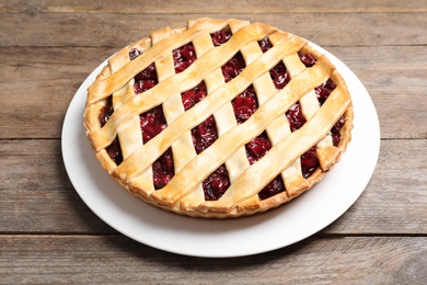 Photo of Delicious fresh cherry pie on wooden table, closeup