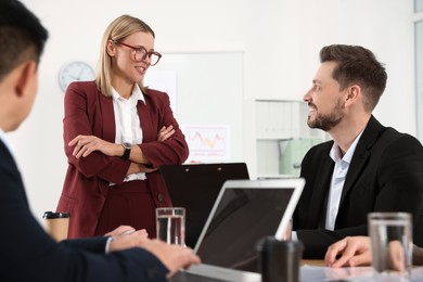 Businesswoman having meeting with her employees in office