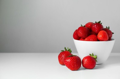 Fresh juicy strawberries on white table, space for text