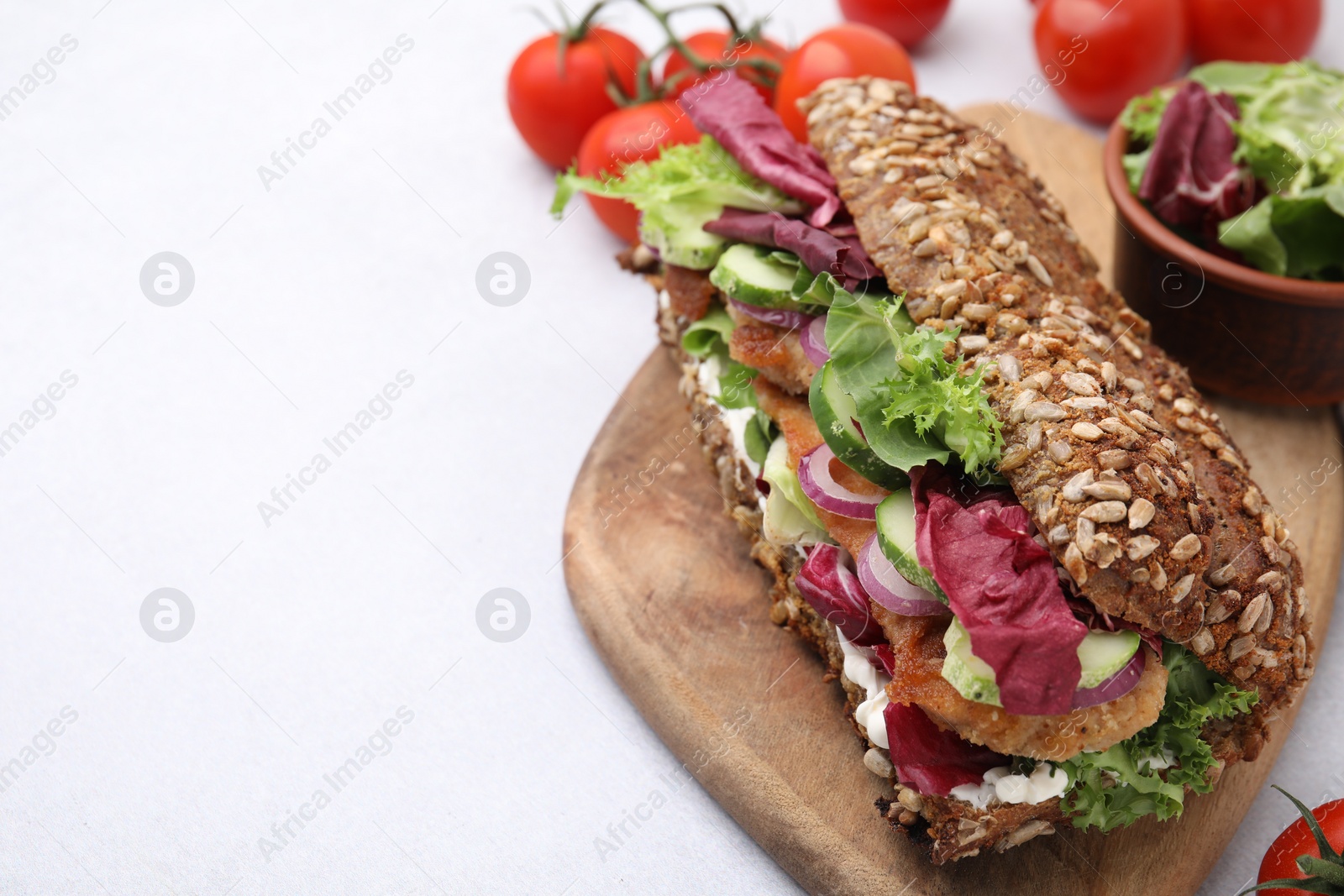 Photo of Delicious sandwich with schnitzel on white table, closeup. Space for text