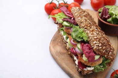 Photo of Delicious sandwich with schnitzel on white table, closeup. Space for text