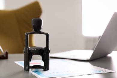 Automatic stamp and documents on desk in notary's office with space for text