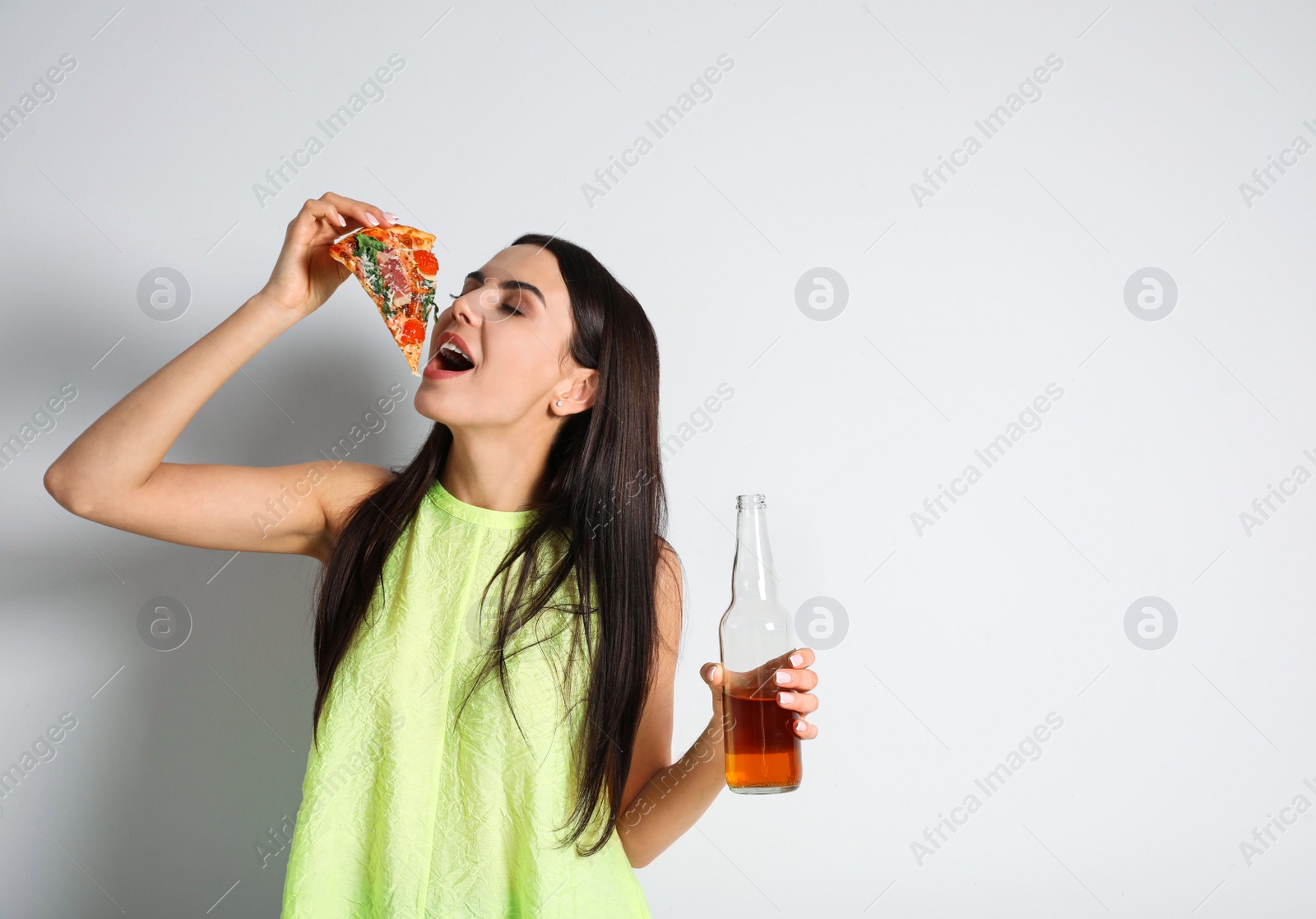 Photo of Happy woman with pizza and beer on white background, space for text