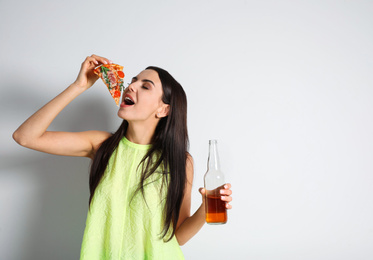 Happy woman with pizza and beer on white background, space for text