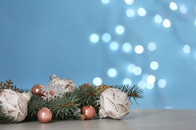 Photo of Christmas decoration on table against blurred lights. Space for text