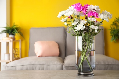 Beautiful bouquet of Chrysanthemum flowers on grey table indoors, space for text. Interior design