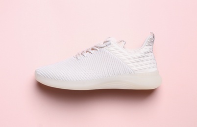 Photo of Stylish sporty sneaker on pink background, top view