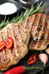 Photo of Delicious grilled pork steaks with spices on table, closeup