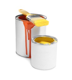 Photo of Cans of different paints and brush on white background