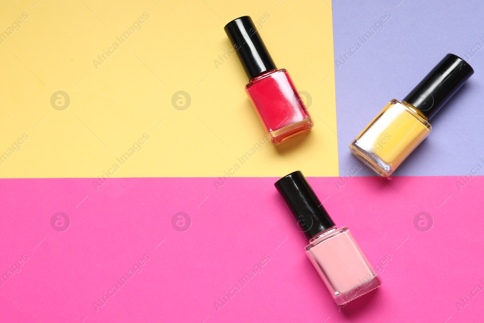 Photo of Nail polishes on color background, flat lay. Space for text