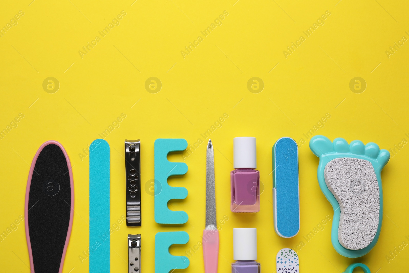 Photo of Set of pedicure tools on yellow background, flat lay. Space for text