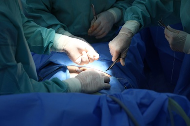 Photo of Medical team performing surgery in operating room, closeup