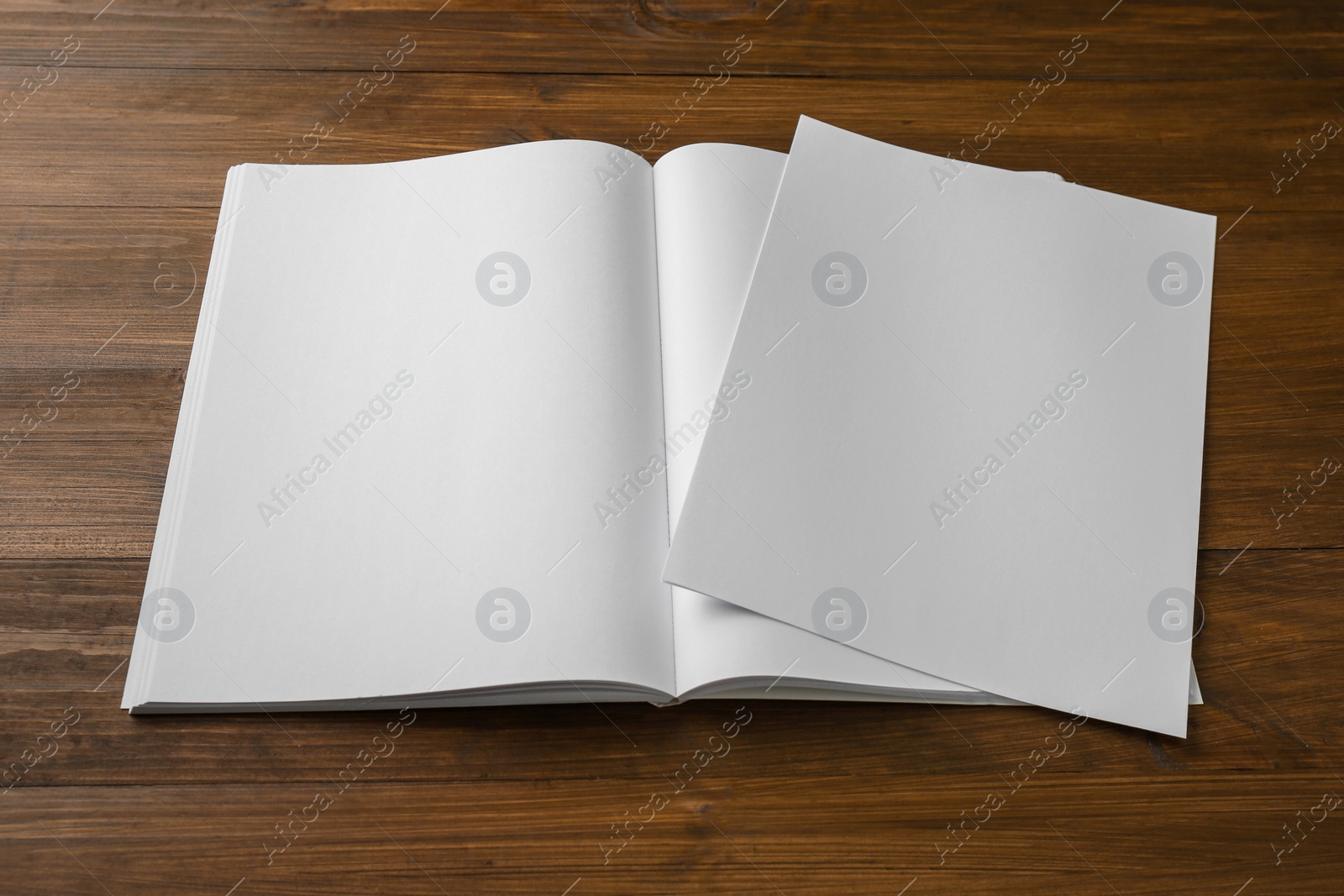 Photo of Sheet of paper and blank brochure on wooden table. Mockup for design