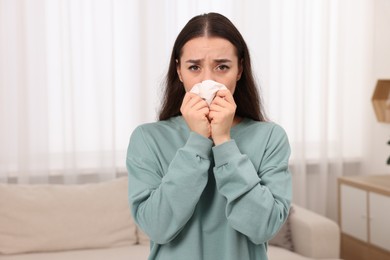 Photo of Sick woman with tissue at home. Cold symptoms