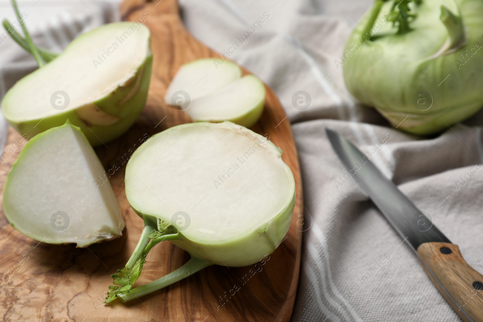 Photo of Cut kohlrabi plants on wooden board, closeup