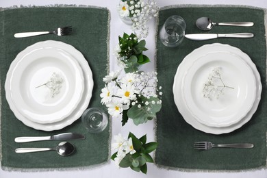 Elegant festive setting with floral decor on table, flat lay