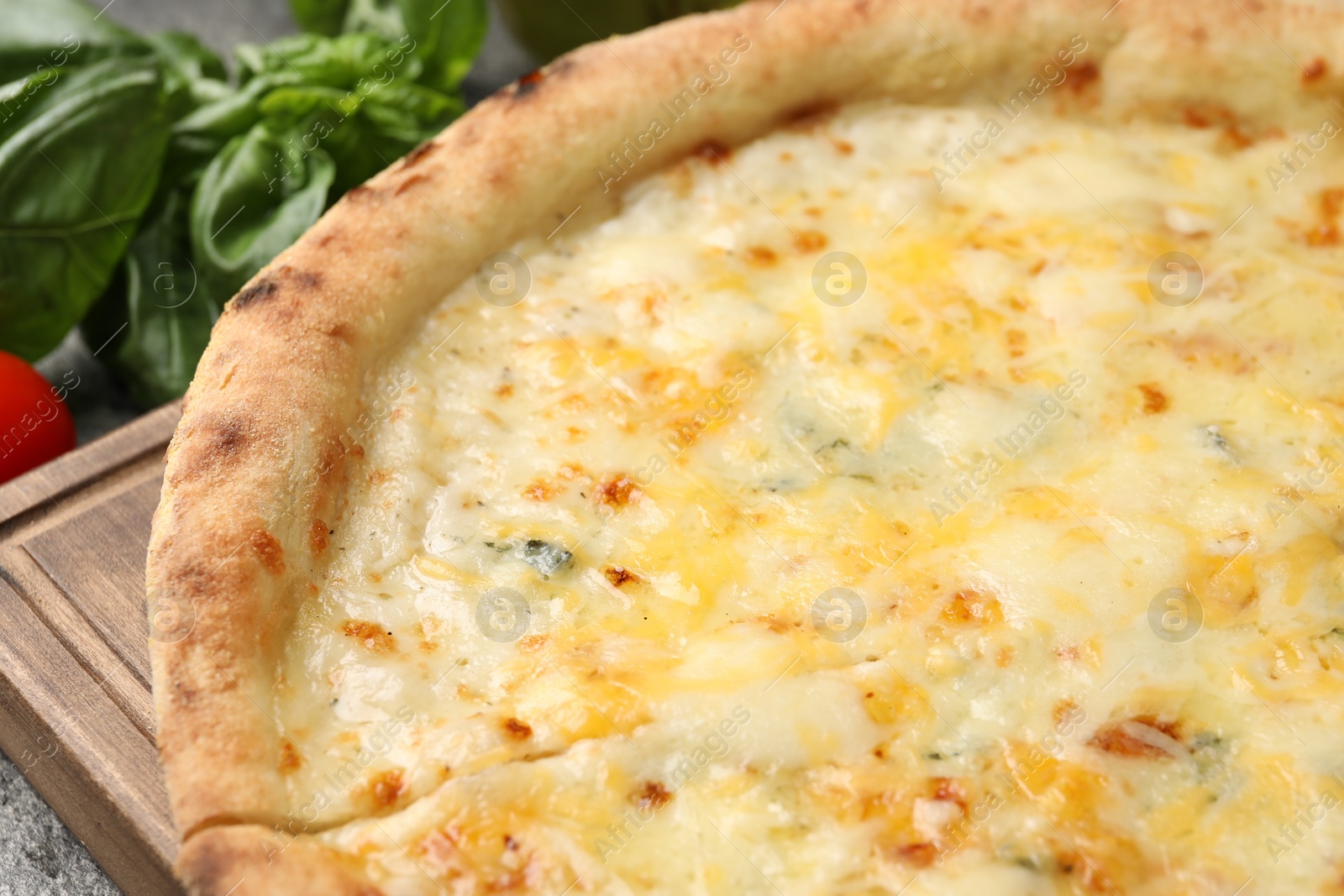 Photo of Delicious cheese pizza and basil on table, closeup