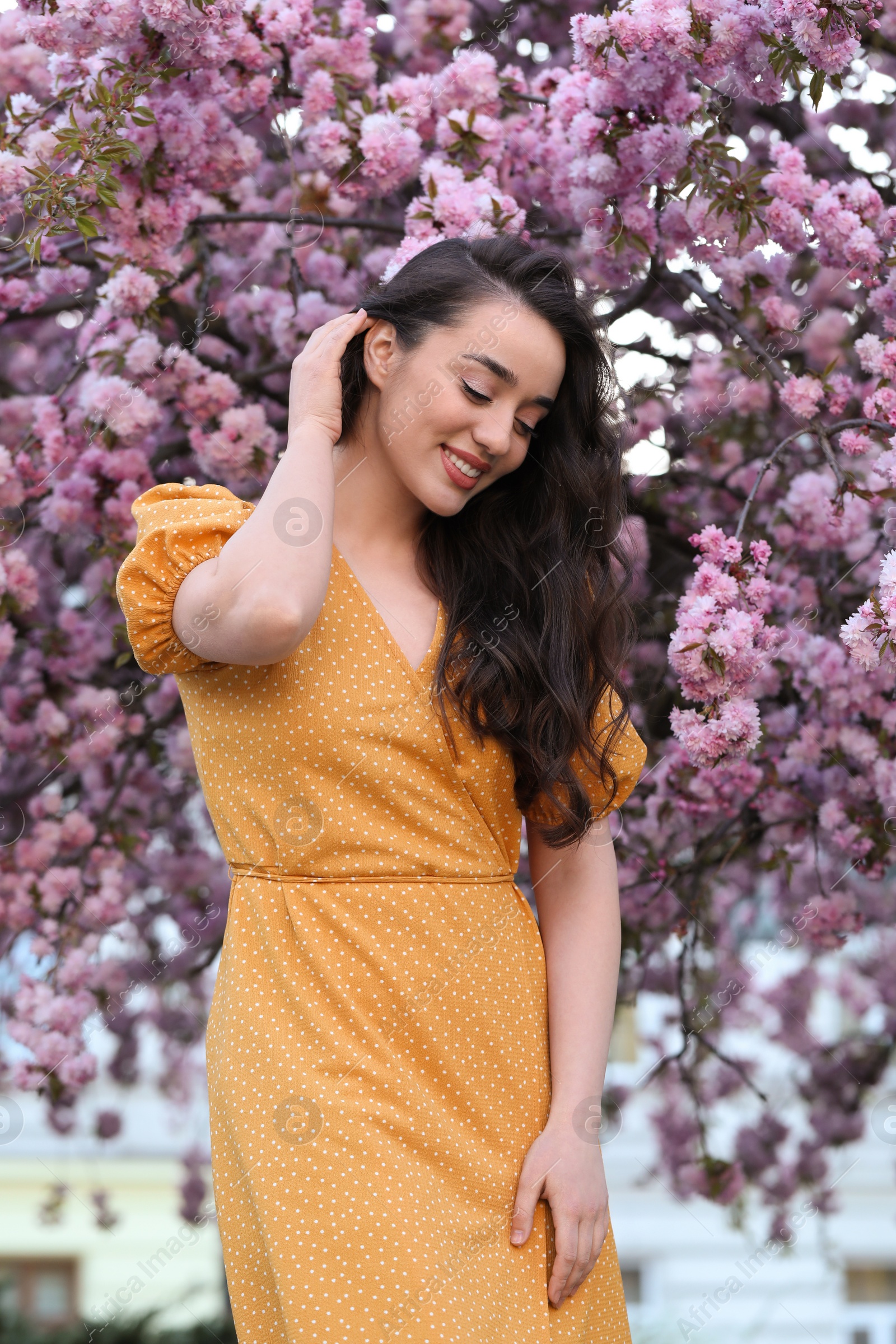 Photo of Beautiful woman near blossoming sakura tree on spring day