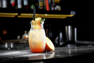 Photo of Fresh alcoholic Tequila Sunrise cocktail on bar counter. Space for text
