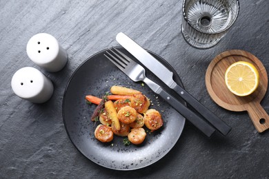 Photo of Delicious fried scallops served on dark gray textured table, flat lay