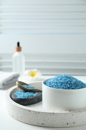 Composition with blue sea salt on white table indoors, space for text