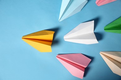 Photo of Yellow paper plane leading others on turquoise background, flat lay. Diversity concept