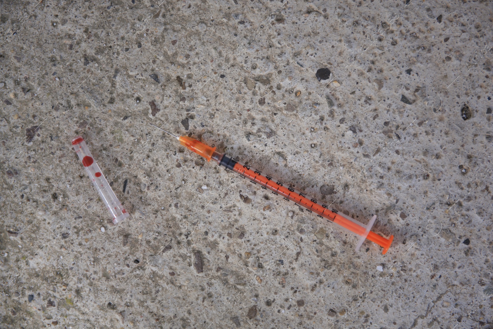 Photo of Disposable syringe with needle on stone surface outdoors, flat lay