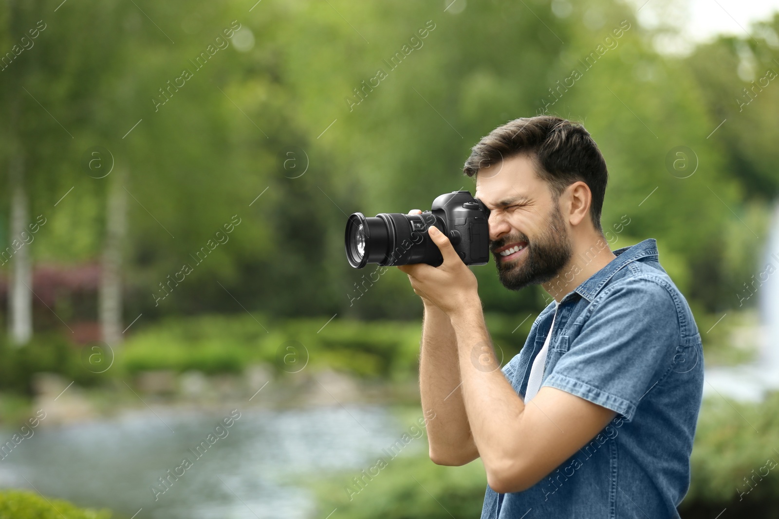 Photo of Photographer taking photo with professional camera in park