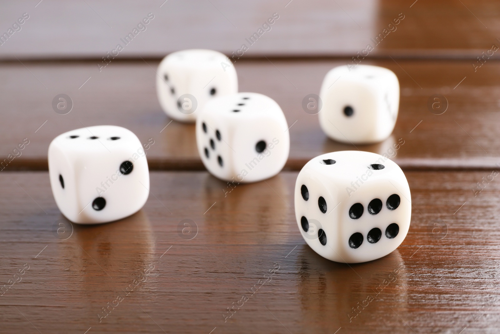 Photo of Many white game dices on wooden table, closeup