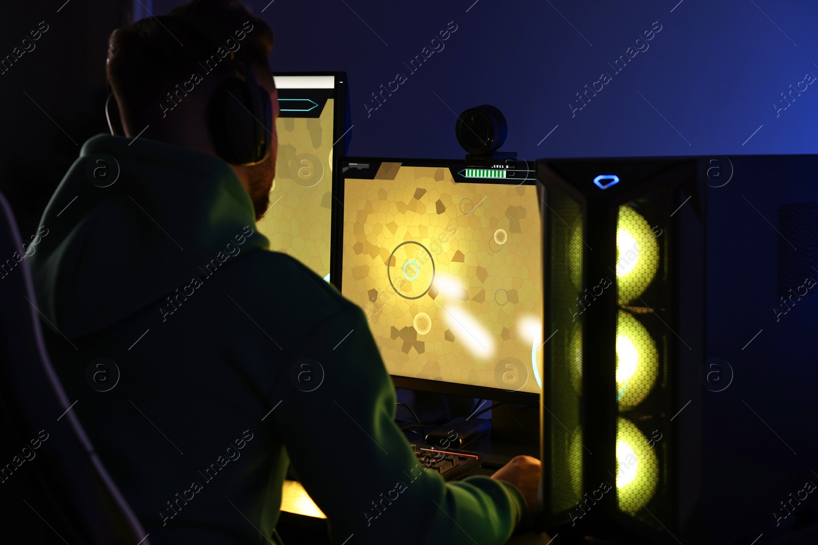 Photo of Man playing video games on computer at table indoors